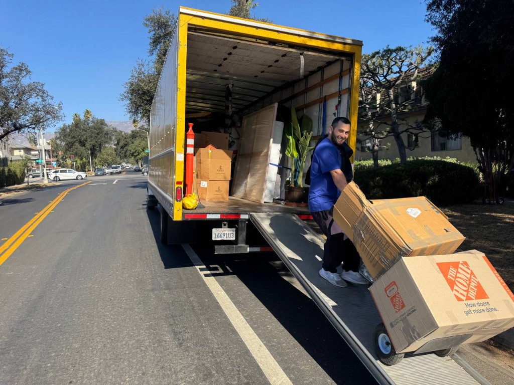 Professional mover loading carefully packed boxes onto a truck